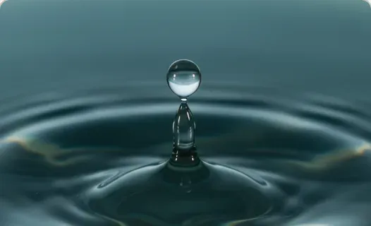 Gota de água tocando a superfície de um lago calmo.
